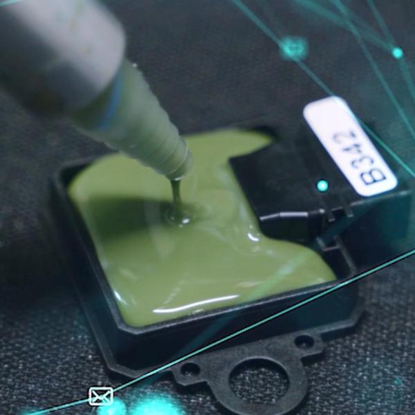 Applicazione di resina protettiva su un componente elettronico durante la fase di potting.